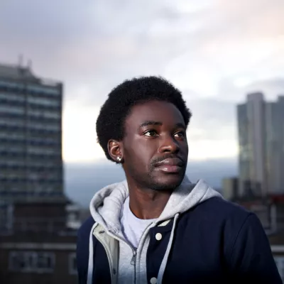 Young person with two high rise buildings in background