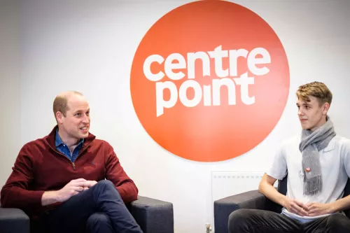 Prince William sitting with a young person with Centrepoint logo behind them