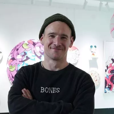 Ed standing in front of his artwork