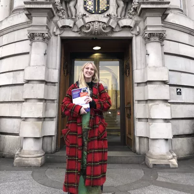 Frankiebo Taylor from the policy team at Centrepoint, holds our latest report outside Lambeth Town Hall