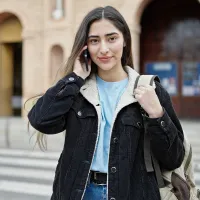 A young woman makes a phone call from the street.