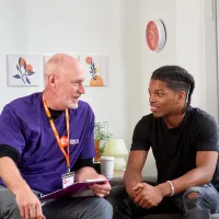 Centrepoint young person and staff member in discussion on sofa