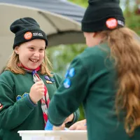 two cub scouts in front of a tent wearing sleep out beanies