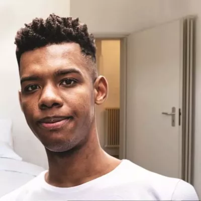 Young person in white T in a bedroom