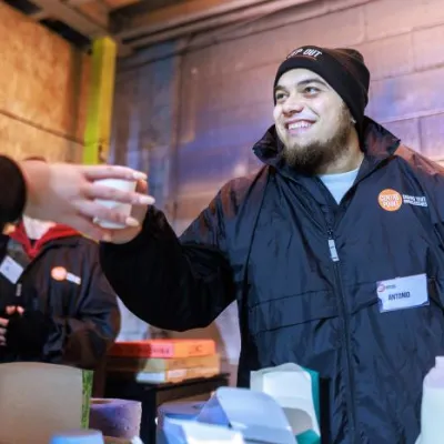 Centrepoint staff hands out a warm drink to a Sleep Out participant