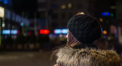 Back of young person wearing a hat at night