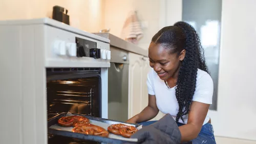 Picture shows a Centrepoint resident taking out some baked goods from an oven.