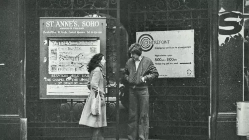 Black and white photograph showing two people outside Centrepoint at St. Anne's Soho in the 1980s