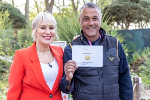 Cleve West, designer of the Centrepoint Garden, proudly holds a certificate with a gold emblem embossed on it