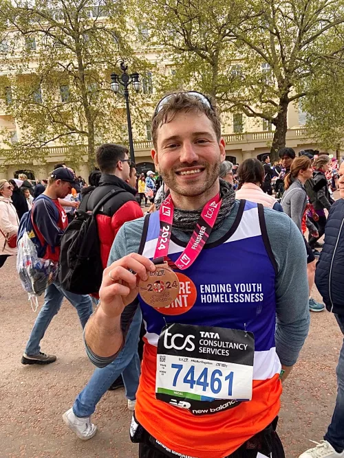 Alexander Lincoln holds his London Marathon medal proudly at the end of the event