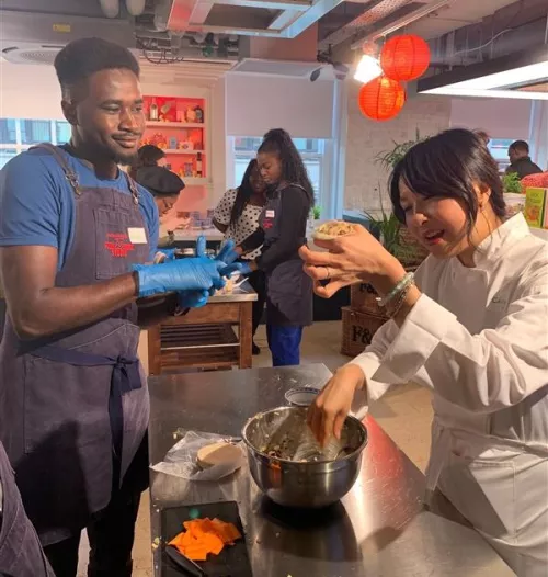 Ching He Huang makes dumplings with a Centrepoint young person