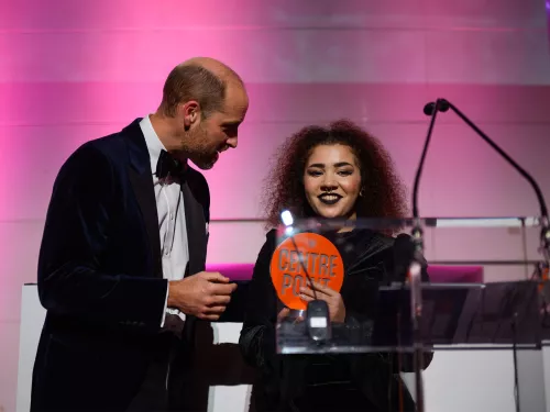 Young person accepting an award from Prince William