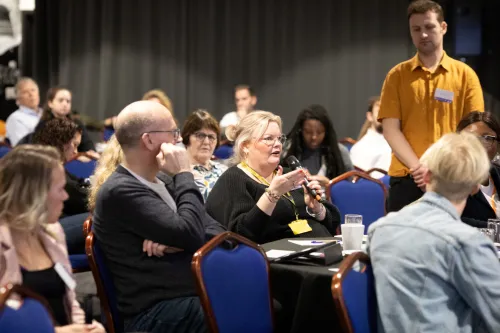 A delegate asks a question during a session