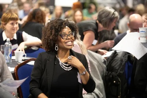 A delegate smiles while watching one of the sessions