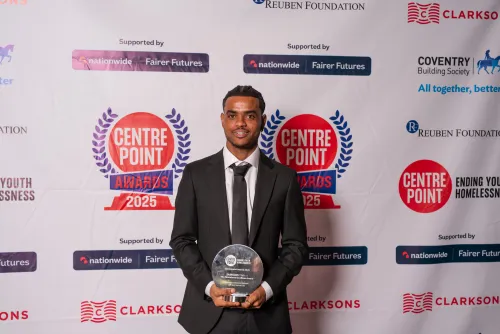 Young man smiling holding an award