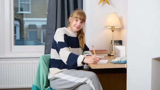 Anna working at her desk in her own room at a Centrepoint service