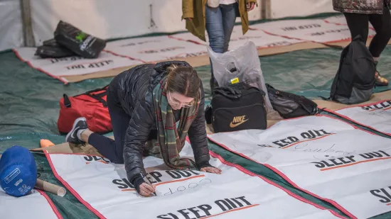 woman puts sleeping bag down on the floor