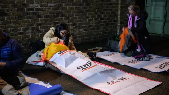 woman sits on floor in sleep out sleeping bag