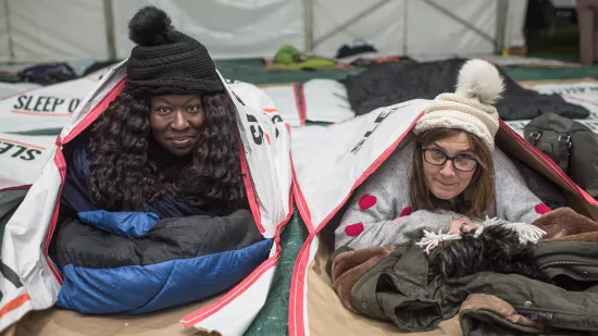 Two women lie in Sleep Out sleeping bags
