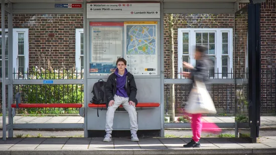 A young person at a bus stop