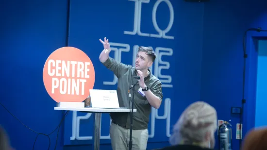 A speaker talks passionately on stage at the conference