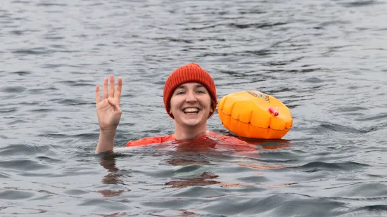 Participant in the water holding up 4 fingers