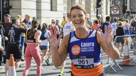 Laura smiles as she runs through the streets of London in her Centrepoint vest for the London Landmarks Half Marathon