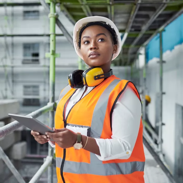 Young person in high vis on building site