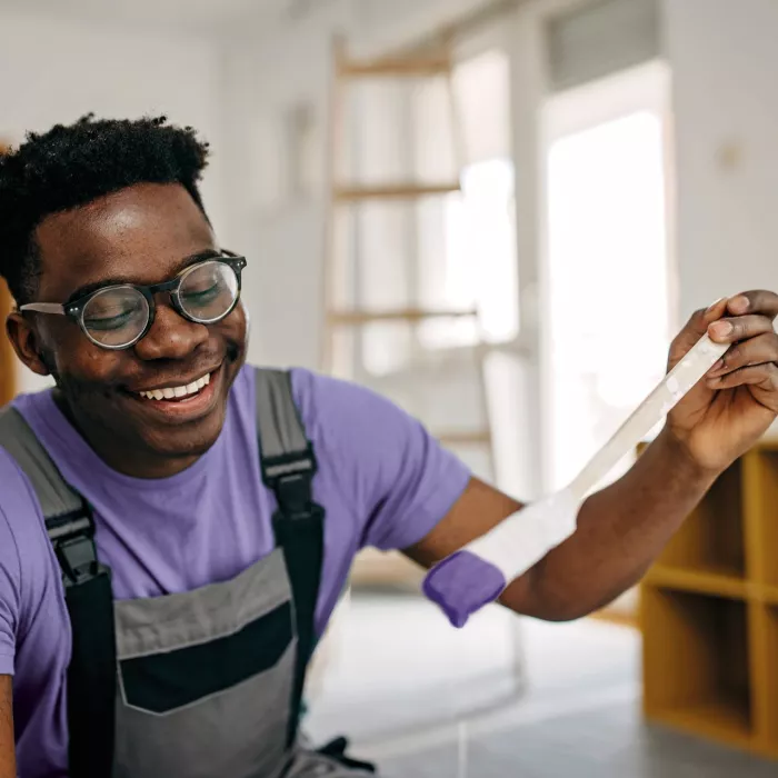 A young man is painting happily.