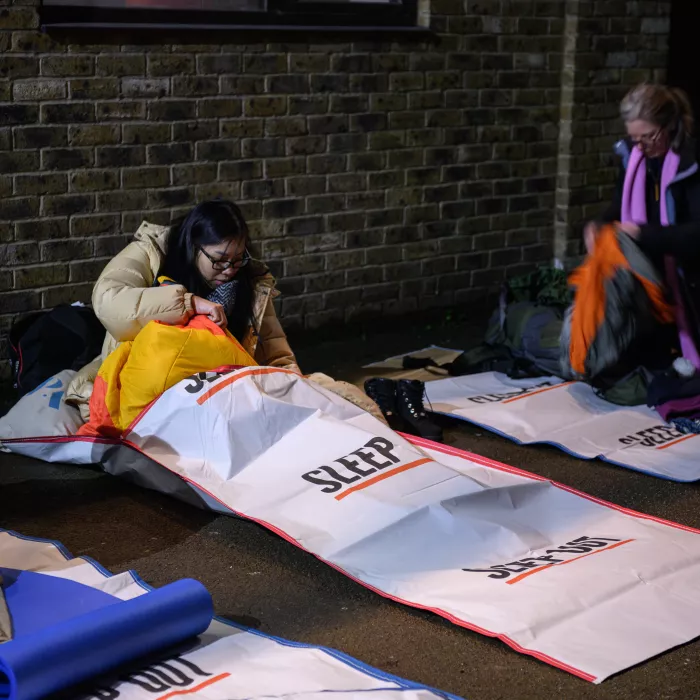 woman sits on floor in sleep out sleeping bag