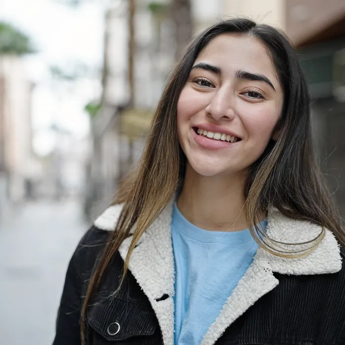 A young woman on the street looks relieved.