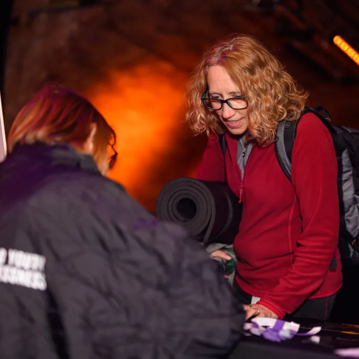 sleep out participant with rucksack and sleeping bag checking into Sleep Out