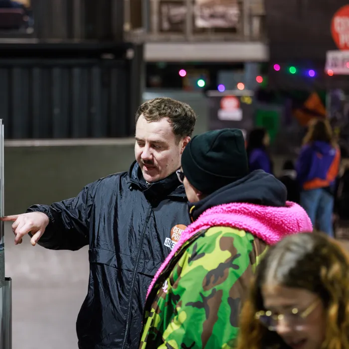 Sleep Out volunteer showing a participant photos of bedding sites