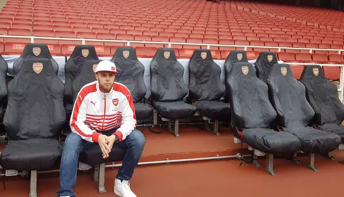 Person sitting alone in Arsenal football stadium