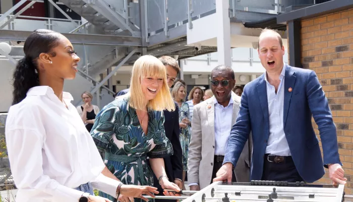 HRH Prince William and Sara Cox playing table football with young people