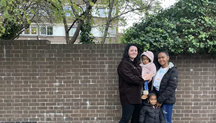 Young woman standing outside with her two young daughters and her key worker