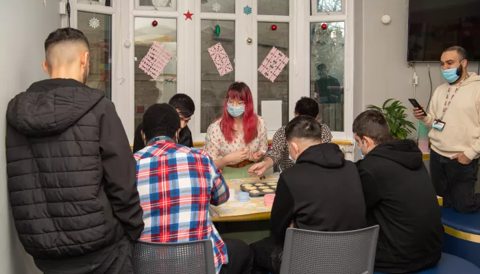 Kim-Joy sits and decorates cupcakes with Centrepoint residents at Christmas