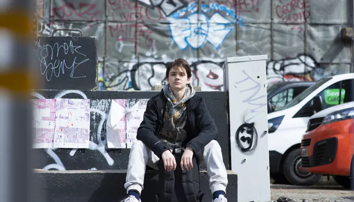 Young person sat down on street side