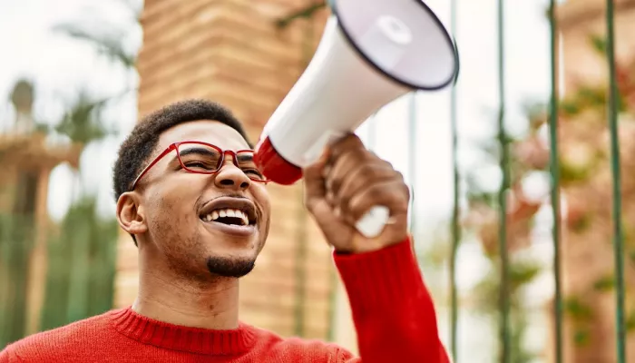 A young man holds a megaphone at a protest