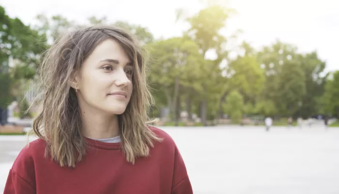 Young person in red sweatshirt looking to the side