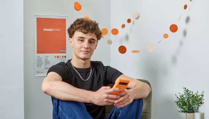 A young person sits in his Centrepoint room looking relaxed