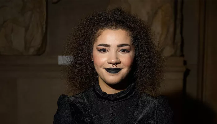 Young person in black dress smiling