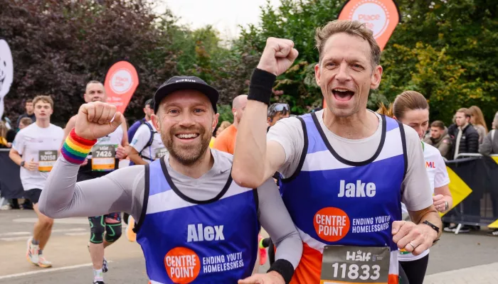 Alex and Jake cheer as they run a marathon wearing Centrepoint running vests