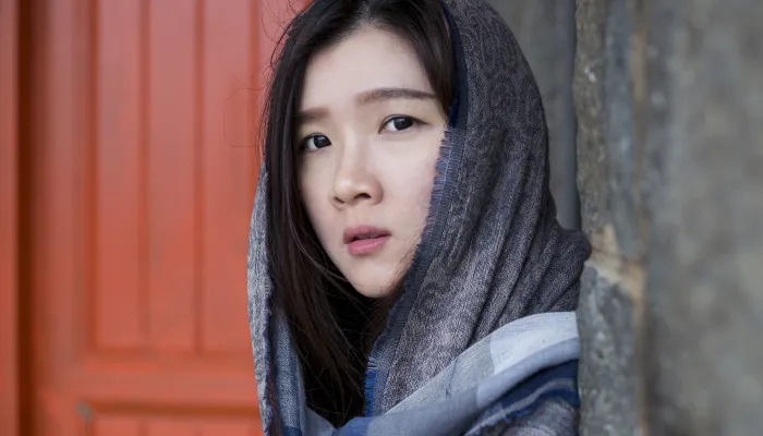 Young women coming round the corner of an alley entrance, looking directly at viewer.