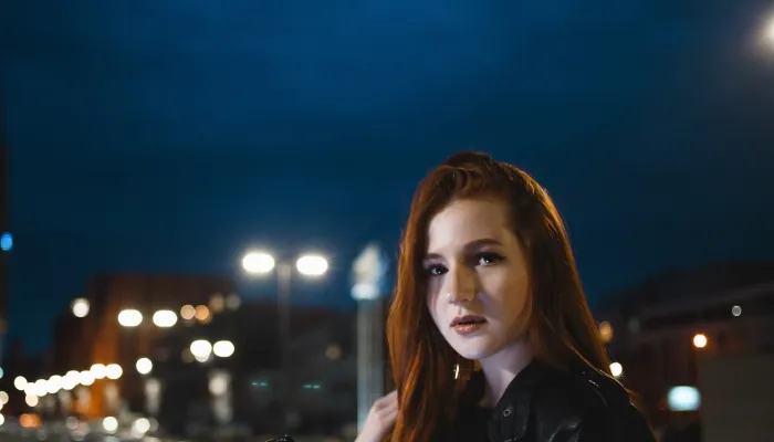 Young women out at night, street lights in the background.