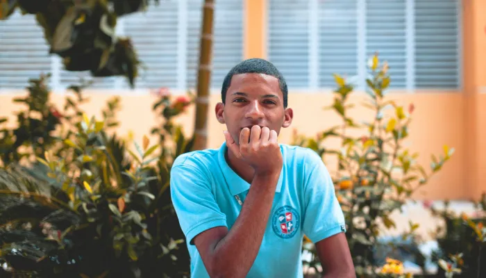 Young man sitting outside looking into camera