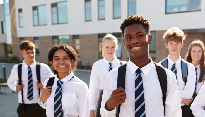 A group of secondary school students stand in the playground