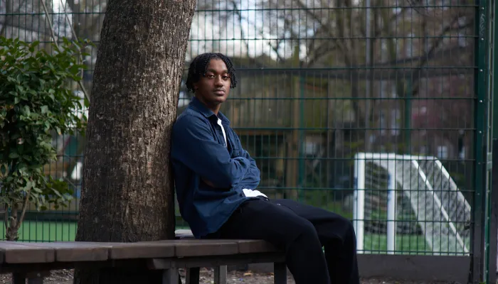 Young person sitting next to a tree