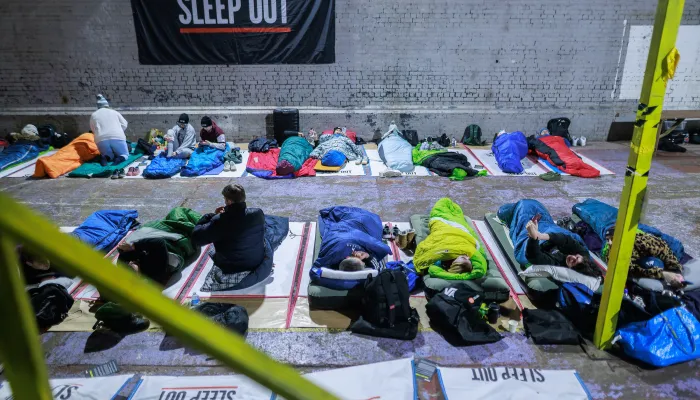 People lie beneath a sleep out banner