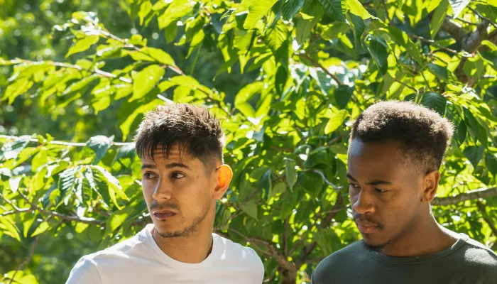 Young men standing in front of a tree